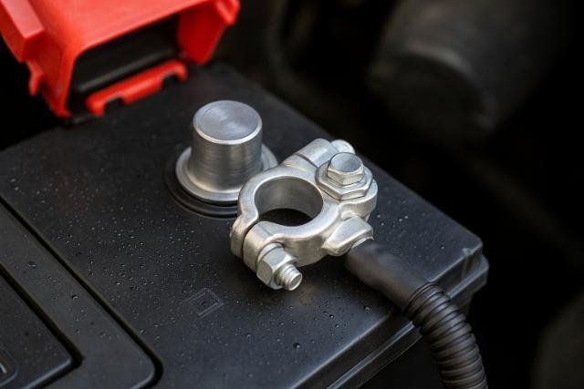 Clean car battery terminal with clamp securely attached.